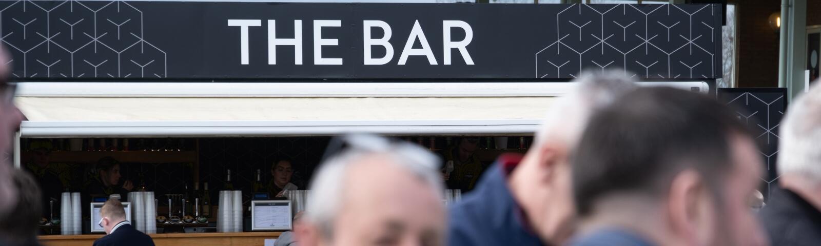 A group of gentlemen stood in front of the bar at Hereford Races