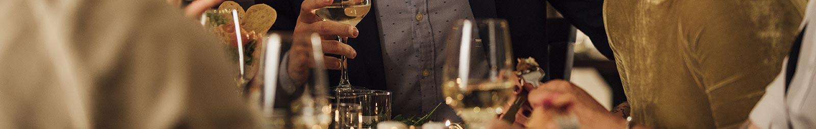 Close up on a group of people holding drinks at a party.