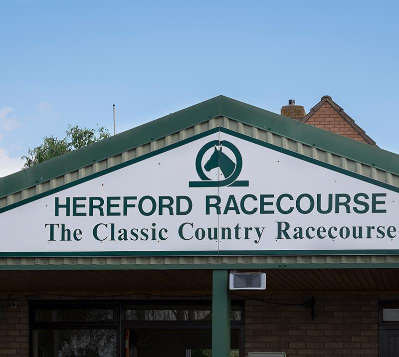 Close up on a entrance building to the Hereford Racecourse with the signage up on the wall.