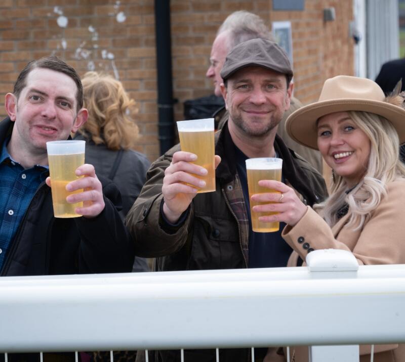 A small group toast their beers to the camera at Hereford Races