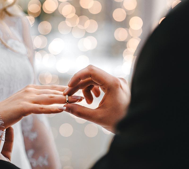 Groom placing ring on brides hand